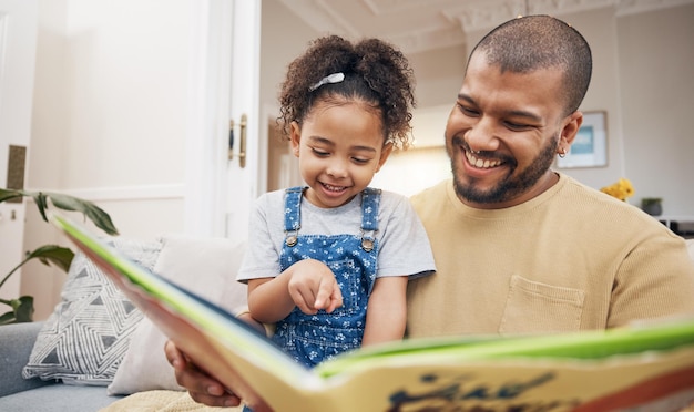 Dad daughter and book on sofa together bonding and love in storytelling in living room with smile Happiness father and child reading story on couch for fantasy learning and education in home fun