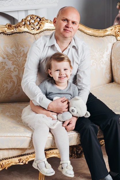 Dad and daughter posing on the couch