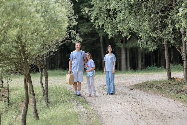 Dad and daughters on a walk in the summer forest