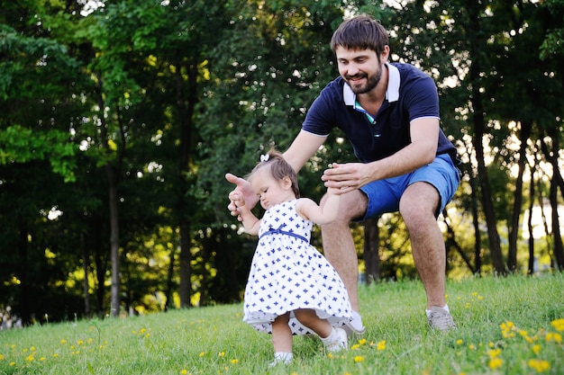 Dad helps little daughter to make first steps