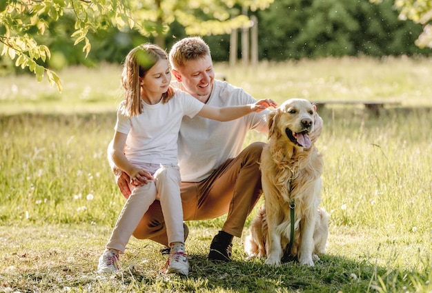 Dad and his daugter play with dog