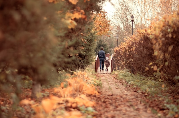 dad holds daughters hand happy family walking in autumn parkhello september