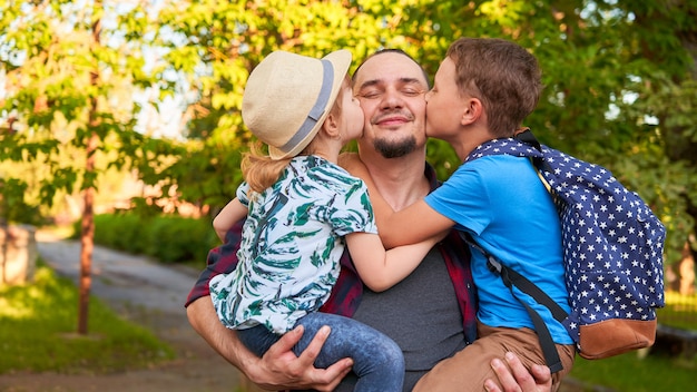 Dad holds kids in his arms