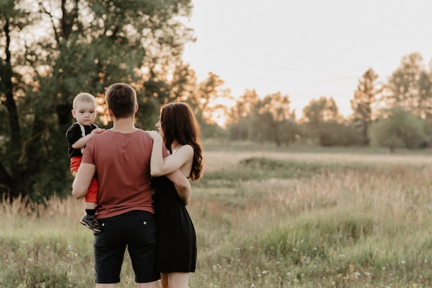 Dad, mom and son in the summer in the field