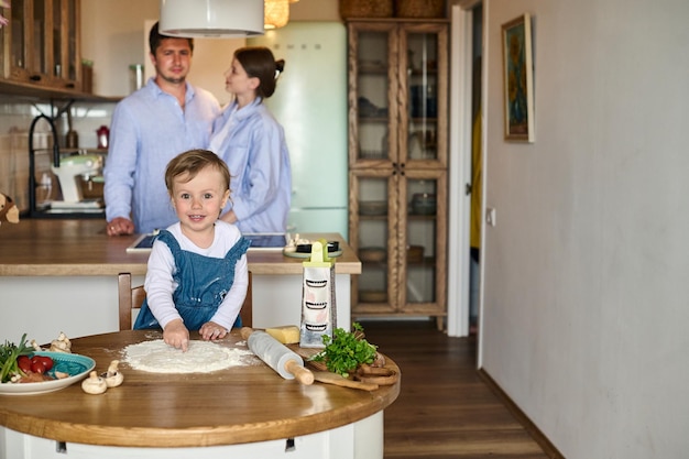 Dad mom and their daughter cook pizza together in the kitchen The concept of a happy family