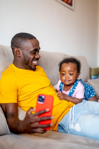 Dad shows his 9-month-old daughter his smartphone