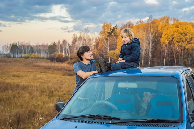 Dad and son are resting on the side of the road on a road trip Road trip with children concept