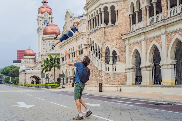 Dad and son on background of Sultan Abdul Samad Building in Kuala Lumpur, Malaysia. Traveling with children concept