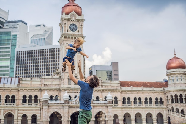 Dad and son on background of Sultan Abdul Samad Building in Kuala Lumpur, Malaysia. Traveling with children concept