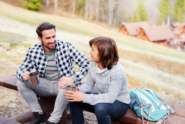 Dad and son drinking tea and sitting on wooden bench