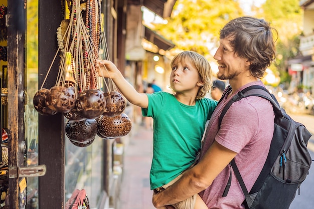 Dad and son at a market in Ubud Bali Typical souvenir shop selling souvenirs and handicrafts of Bali at the famous Ubud Market Indonesia Balinese market Souvenirs of wood and crafts of local