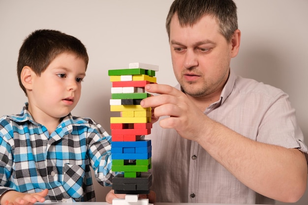 Dad and son play a board game of jenga