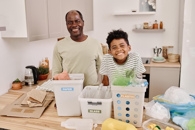 Dad and son sorting garbage in kitchen