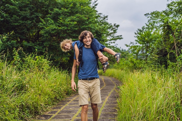 Dad and son tourists in Campuhan Ridge Walk , Scenic Green Valley in Ubud Bali. Traveling with children concept