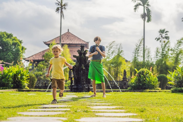 Dad and son tourists in Traditional balinese hindu Temple Taman Ayun in Mengwi. Bali, Indonesia Traveling with children concept