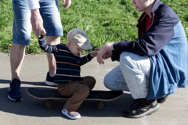 A dad teaches his young son to skateboard with his eldest son for three years