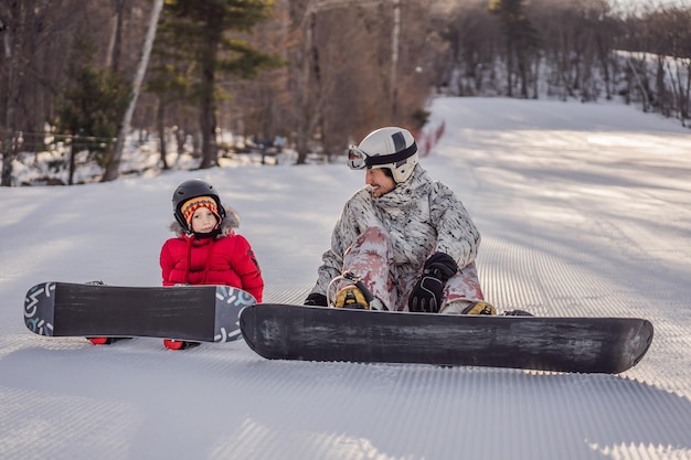 Dad teaches son snowboarding Activities for children in winter Children's winter sport Lifestyle