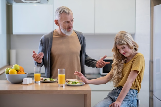 Dad trying to make his daughter eat breakfast