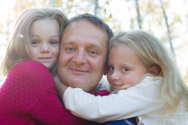 Dad with daughters hugging closeup