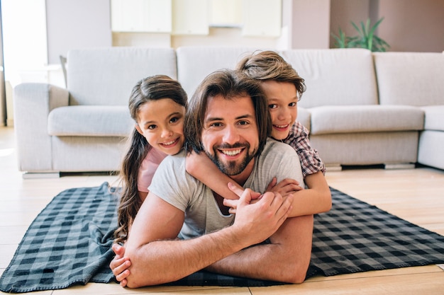 Dad with his kids lying on the blanket on the floor