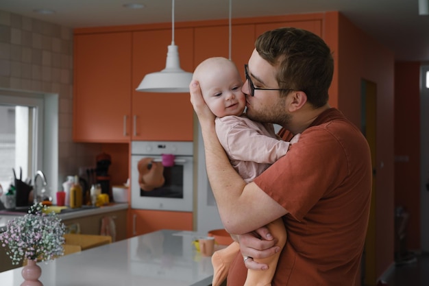 Daddy with baby girl in his hands cuddling at home