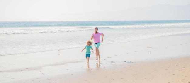 Daddy with kid boy in sea. weekend family day. dad and child have fun outdoors. father and son running on summer beach. family travel weekend and vacation. childhood and parenting.