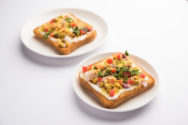 Dahi Bread papdi chaat, chat is a yummy starter or appetizer from India, served in a plate garnished with tomato, sev and coriander and masala. selective focus