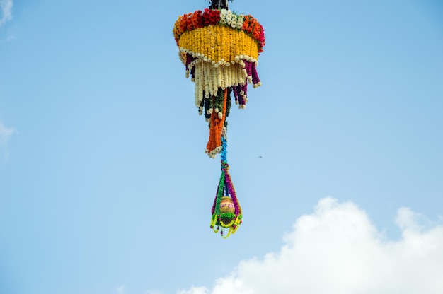 Dahi Handi background on Gokul Ashtami festival with hanging pot filling with curd with flower decoration