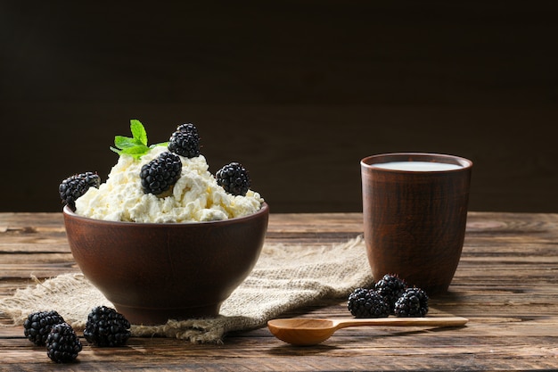 Dairy product cottage cheese and milk in brown ceramic bowl