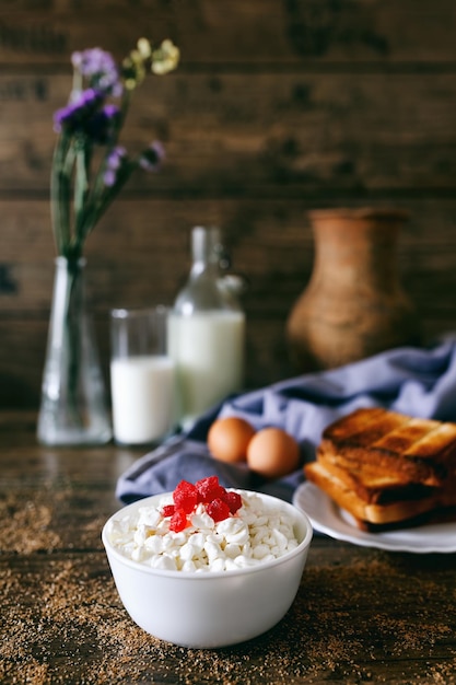 Dairy products on dark wooden table sour cream milk cheese egg and toasts selective focus