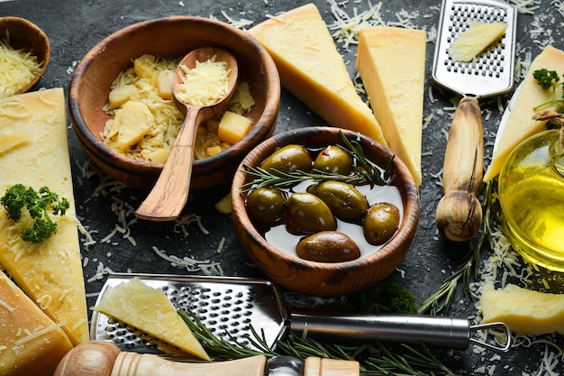 Dairy products Parmesan cheese olives and snacks on a stone table Top view On a concrete background