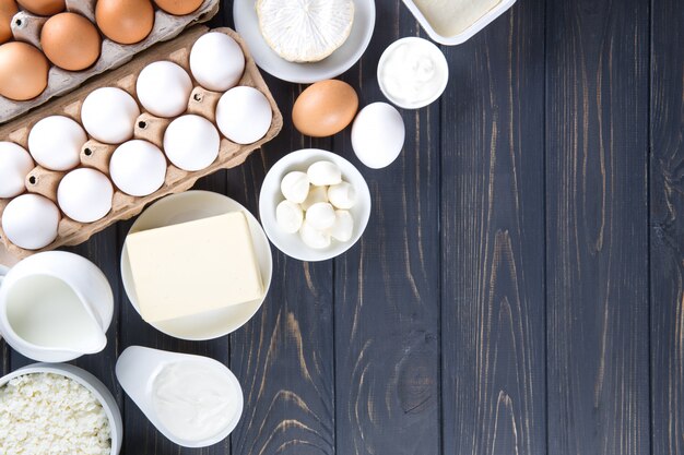 Dairy products on wooden table. Milk, cheese, egg, curd cheese and butter.