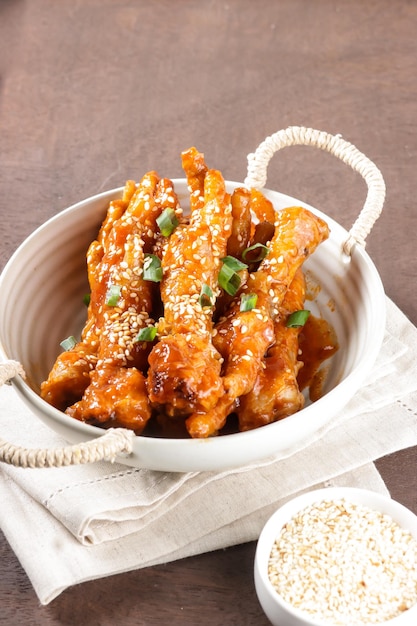 Dakbal or Maeun Dakbal is Spicy Chicken Feet, Korean Food Style served with sesame seeds and Kimchi.