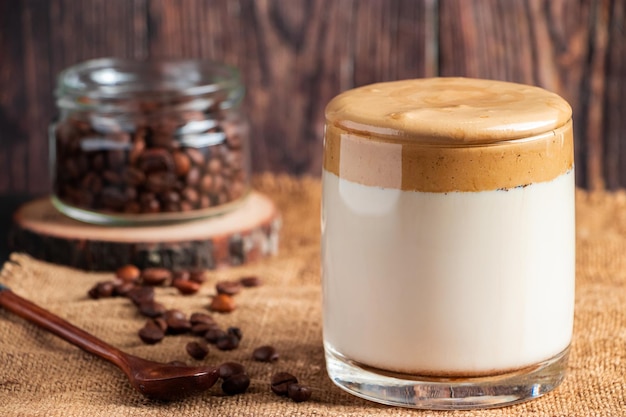 Dalgona coffee on a wooden background A glass of trendy drink made from milk and whipped foam