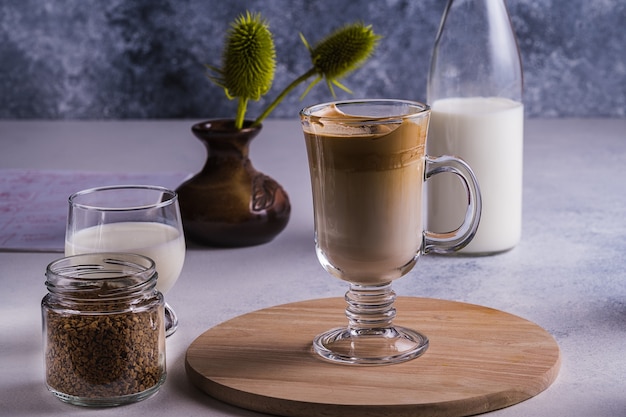 Dalgona espresso latte and ingredients for its preparation on a gray table. Selective focus.