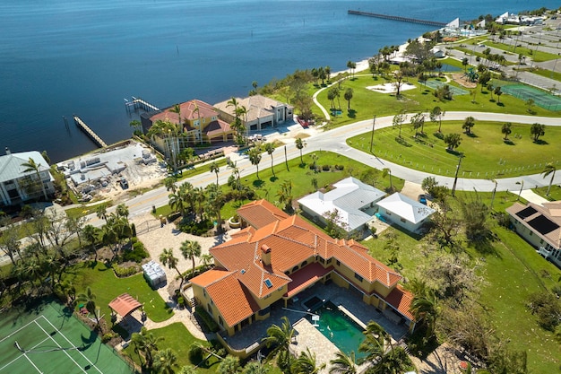 Damaged home rooftops after hurricane Ian in Florida coastal residential area Consequences of natural disaster