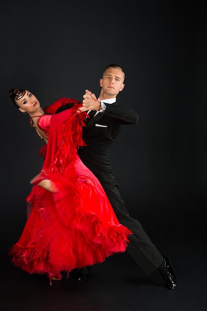 Dance ballroom couple in a dance pose on black background. sensual professional dancers dancing walz, tango, slowfox and quickstep.