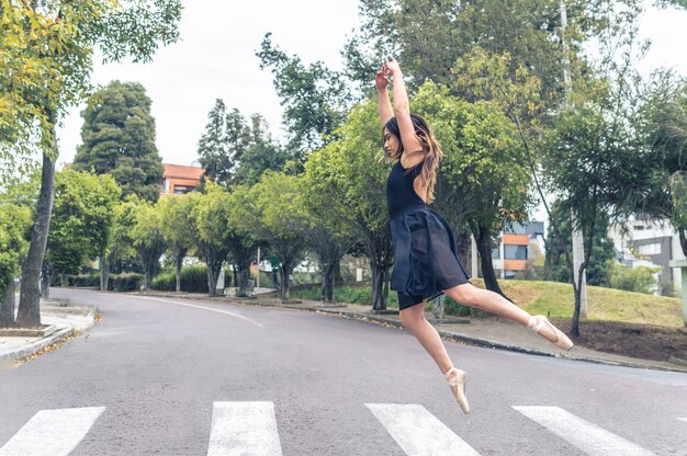 Dancer jumping with arms up over a pedestrian crossing