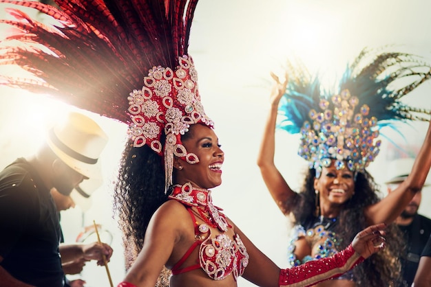 Dancing is part of our life Shot of two female dancers wearing vibrant costumes while dancing to music inside of a busy nightclub