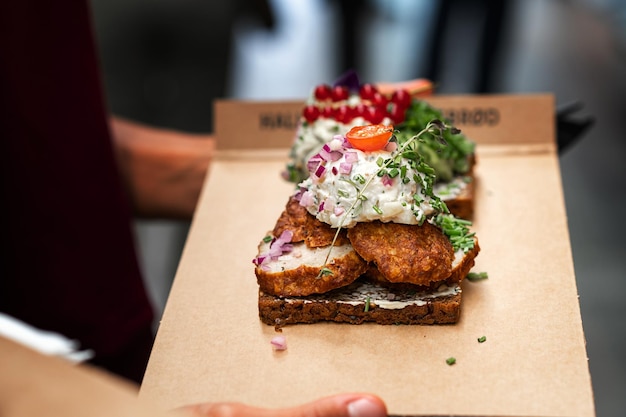 Danish open sandwich made of rye bread meatballs and sauce man buying fast food meal lunch in a cafe