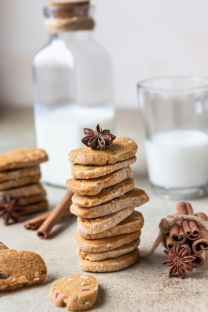 Danish spicy butter cookies with candied fruits, cinnamon sticks and anise and glass of milk.