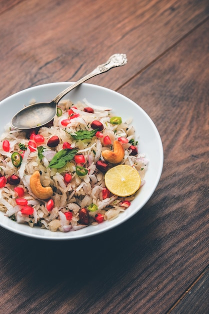 Dapde Pohe is a typical Maharashtrian breakfast, made with thin variety of poha and fresh coconut with chilli, peanuts and nuts. served in a bowl or plate. selective focus