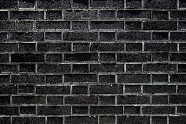 Photo the dark black brick wall has a rough surface as a background image.