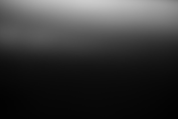 Dark black and gray blurred gradient background has a little abstract light