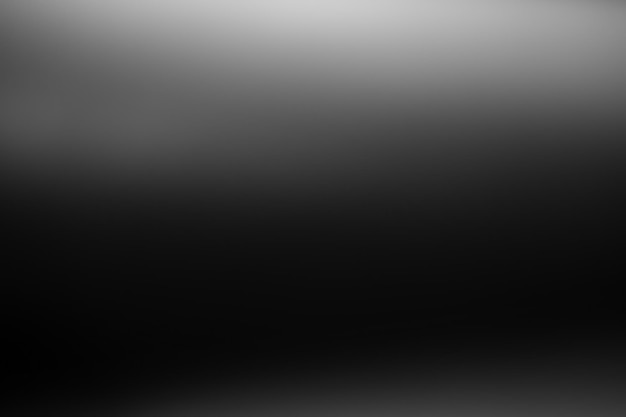 Dark black and gray blurred gradient background has a little abstract light