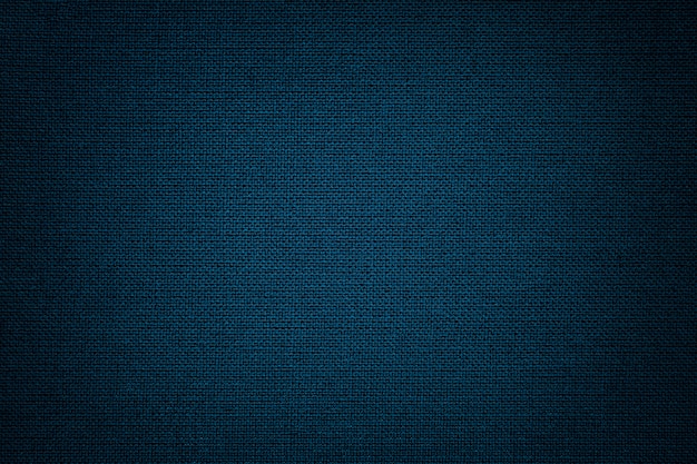 Dark blue background from a textile material. Fabric with natural texture. Backdrop.