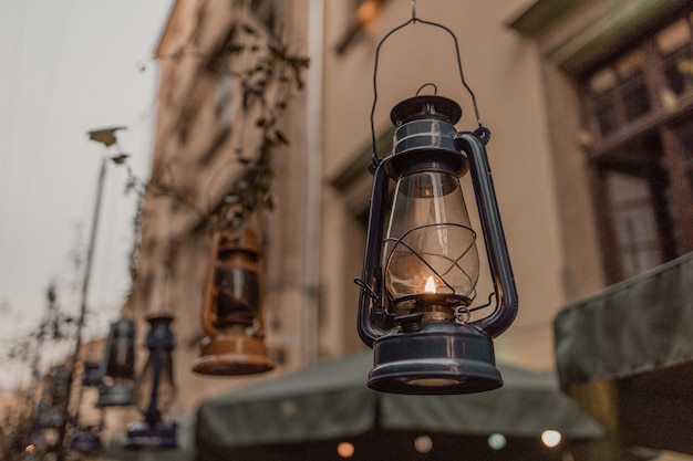 Dark blue kerosene lamp decor with dramatic lighting hanging on the city street in the evening