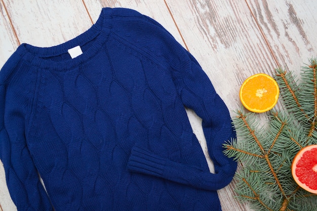 Dark blue knitted sweater close-up fir twig. Fashion 