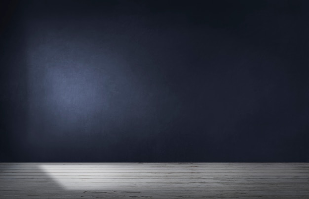 Dark blue wall in an empty room with a concrete floor