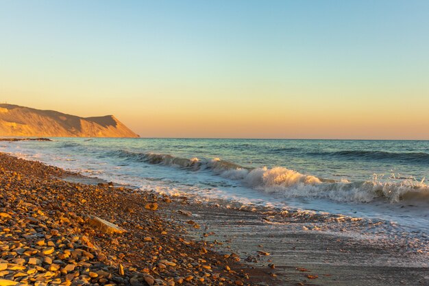 Dark blue waves against the beautiful orange sunset at the Black Sea, Anapa, Russia